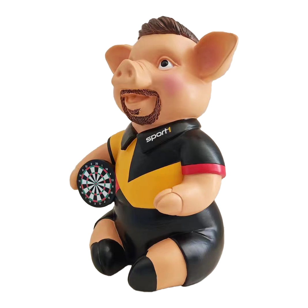 Sport1 Deutschland Phrasenschwein Das Bild zeigt eine Sparschwein-Figur in Form eines Schweins, das ein Dartbrett hält. Das Schwein trägt ein Trikot mit der Aufschrift "Sport1" und ist Teil des Produkts "Sport1 Deutschland Phrasenschwein 2024".