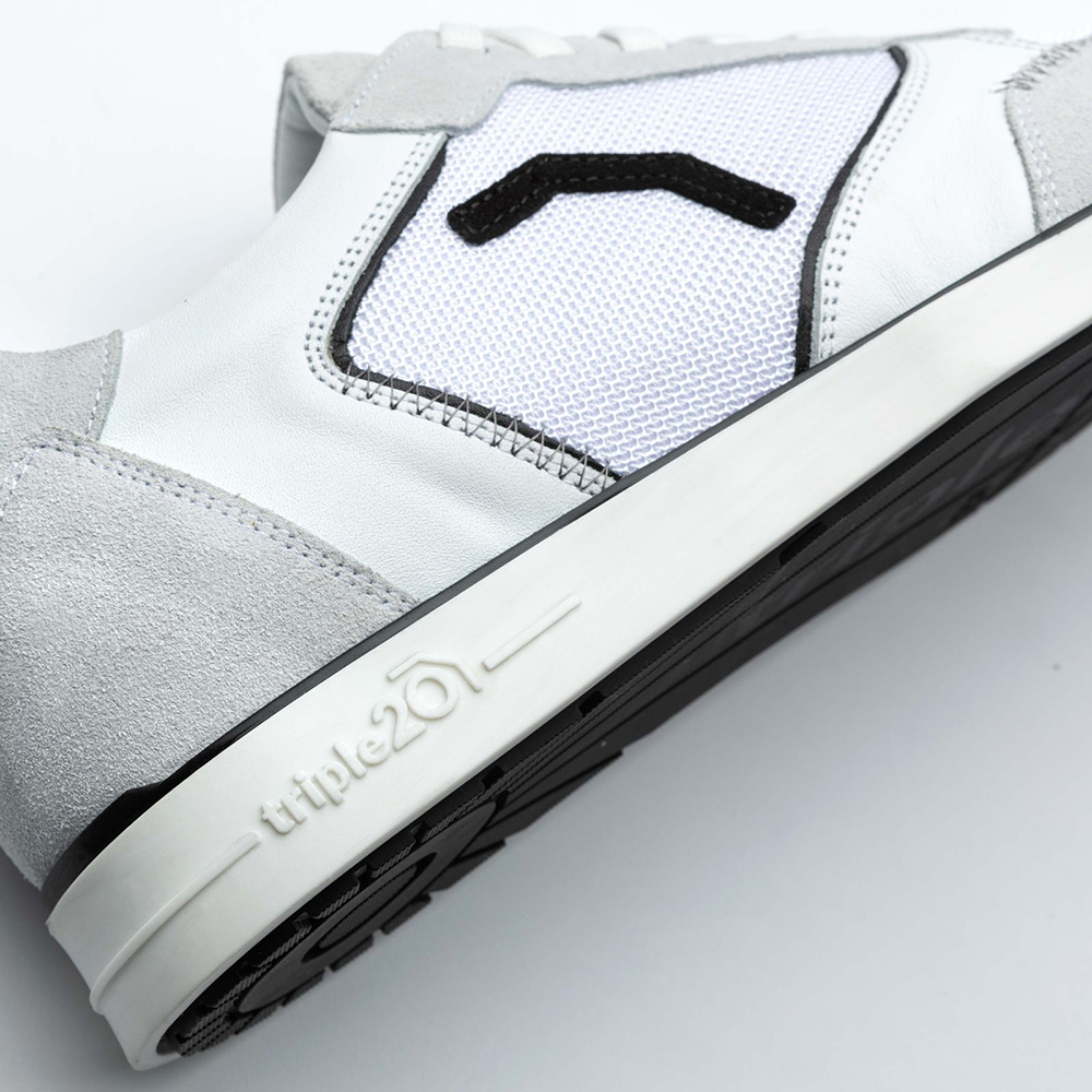 20200004-00_Triple20_Dartschuhe_Textil_Leder_Weiss_Schwarz_5 Der Schuh „Triple20 Dartschuhe Textil Leder - Weiß Schwarz“ ist auf dem Bild in einer Nahaufnahme zu sehen. Er besteht aus weißem Leder mit schwarzen und grauen Akzenten sowie einer weißen Sohle.