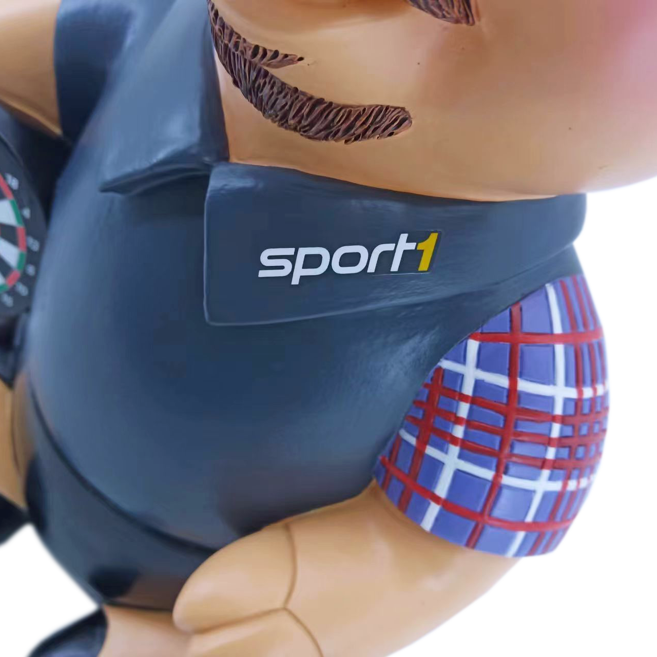Sport1 Legenden Phrasenschwein Auf dem Bild ist das Produkt "Sport1 Legenden Phrasenschwein 2024" zu sehen. Es zeigt eine Figur mit einem sportlichen Hemd und dem Logo von Sport1 auf der Brust.