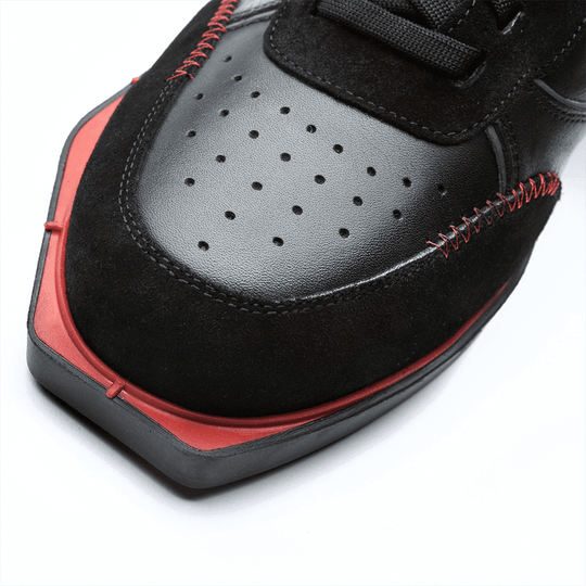20101001-00_Triple20_Dartschuhe_Leder_Schwarz_Rot_4 Der Schuh besteht aus schwarzem Leder mit roten Akzenten und auffälligen roten Nähten. Die Schuhspitze ist kantig geformt und hat kleine Belüftungslöcher.