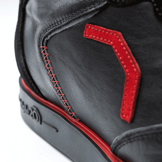 20101001-00_Triple20_Dartschuhe_Leder_Schwarz_Rot_5 Der Schuh besteht aus schwarzem Leder mit auffälligen roten Nähten und Applikationen. Auf der Sohle ist zudem ein roter Streifen zu sehen.