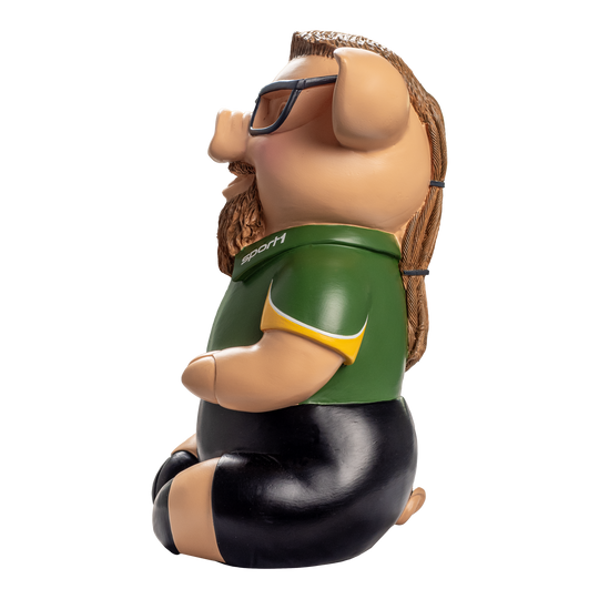 Sport1 Zaubermeister Phrasenschwein Das Bild zeigt ein lustiges Sparschwein in Form eines Schweins mit Brille, langen Haaren und Bart. Das Sparschwein trägt ein grünes Sport1-Trikot und schwarze Hosen.
