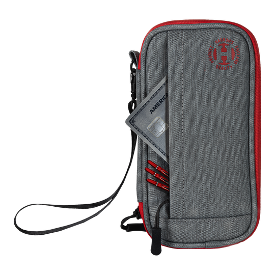 Harrows Smart Case Dartwallet Das Bild zeigt ein graues und rotes Dart-Etui mit einem Reißverschluss und einer Handschlaufe. In der Vordertasche stecken eine Kreditkarte und einige Dartspitzen.