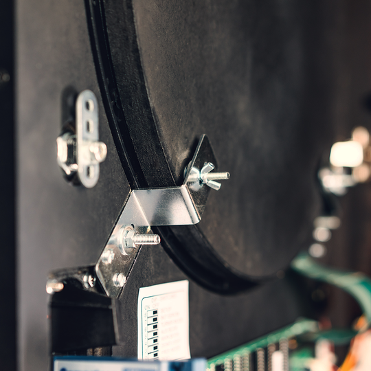 Karella_E-Master_Dartautomat_Detail_Innenansicht_Az5JJqnA8xyX1m Das Bild zeigt einen Nahaufnahmebereich des Karella E-MASTER Dartautomaten ohne Münzeinwurf. Zu sehen sind Metallbefestigungen und elektronische Bauteile im Inneren des Geräts.