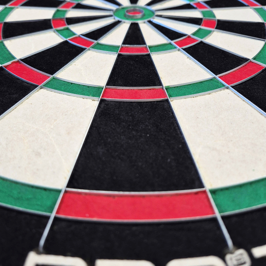Harrows Quadro 240 Steeldartboard Das Bild zeigt eine Nahaufnahme des Harrows Quadro 240 Steeldartboards. Die Farbfelder in Schwarz, Weiß, Rot und Grün sind deutlich zu erkennen.