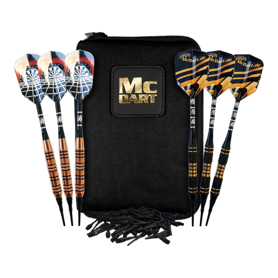 McDart Tasche mit 6 Softdarts und Zubehör Das Bild zeigt eine schwarze McDart-Tasche mit goldener Aufschrift. Davor liegen sechs Softdarts und etwas Zubehör.